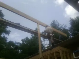 Carpenter setting a ridge beam over a new addition frame — Ice Dam Removal by Roofing Brothers in Oldtown