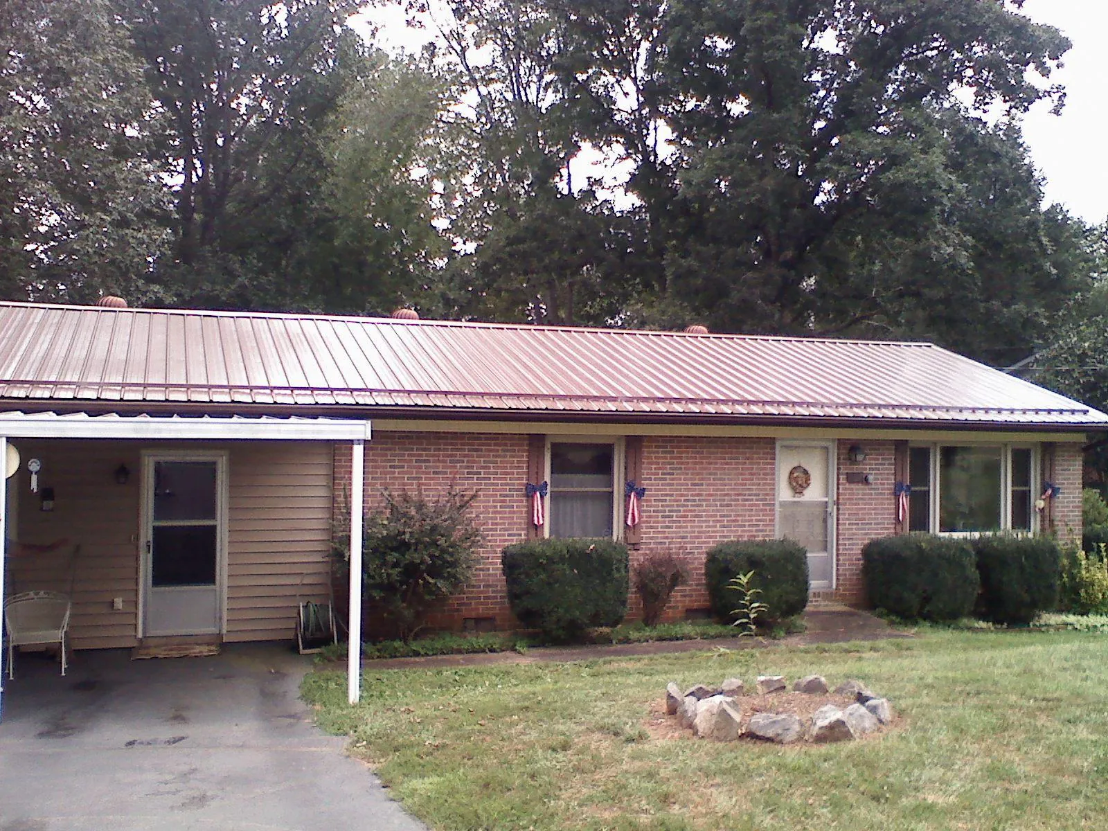 Bronze metal roof and carport on a brick ranch home — Roof Repair work by our crew in Oldtown